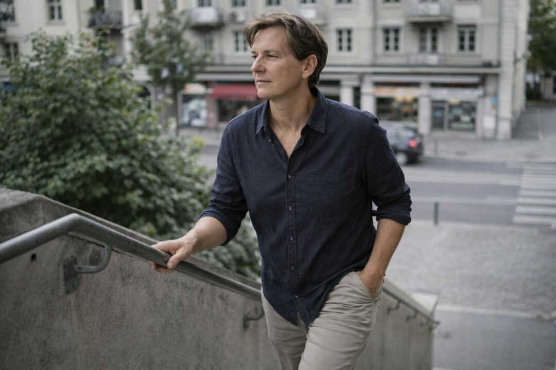 Personne adulte montant quelques marches à Neuchâtel, posture correcte mais plus engagée, illustrant un effort discret devenu plus constant au quotidien